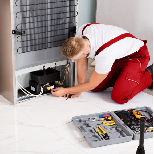 Technician providing expert refrigerator repair service in Buffalo, NY, fixing a fridge for optimal cooling performance.